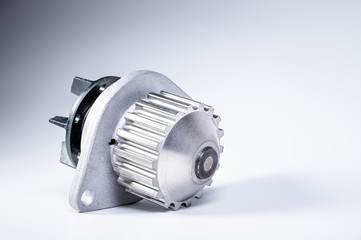 New metal automobile pump for cooling the engine of a water pump on a gray background. The concept of new spare parts for the car engine