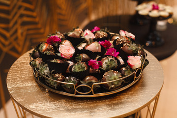 stylish candy bar on the birthday or wedding festive party close up. sweets and delisious desserts on a festive table decorated with flowers. set of  beautiful cakes on the plates on the holiday
