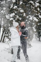 Couple playing with snow in the forest
