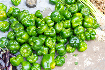 Pile of fresh green sweet bell peppers for sale on street food market in India, Varanasi