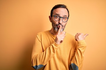 Middle age hoary man wearing casual sweater and glasses over isolated yellow background asking to...