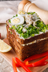 a huge herring sandwich with mayonnaise and quail eggs