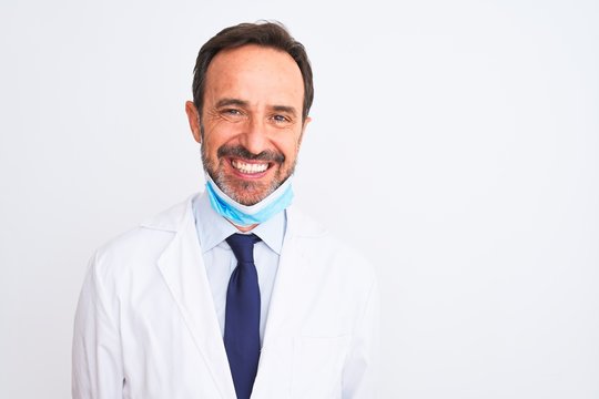 Middle age scientist man wearing coat and medical mask over isolated white background with a happy and cool smile on face. Lucky person.