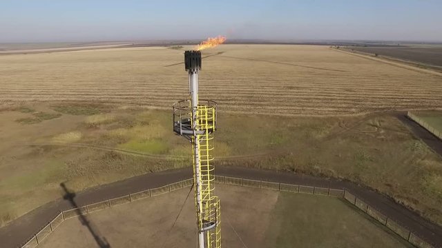 gas flare of petroleum refinery in field, aerial view, closeup