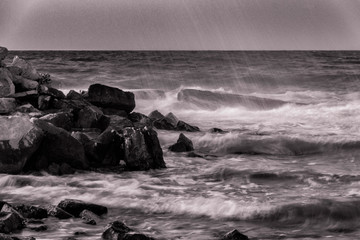 onde sugli scogli col mare in tempesta bianco e nero