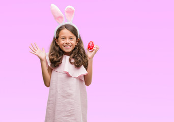 Obraz na płótnie Canvas Brunette hispanic girl wearing easter rabbit ears very happy and excited, winner expression celebrating victory screaming with big smile and raised hands