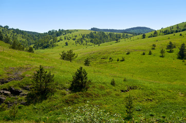 Fototapeta na wymiar Idyllic mountain landscape - with hills, pastures, fields and valleys - in spring