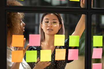 Asian female employee work with sticky notes in office