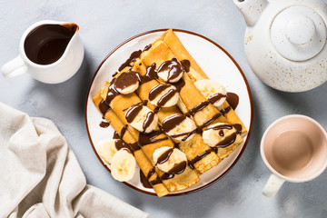 Crepes with chocolate and banana top view.