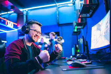 Professional gamer playing tournaments online video games computer with headphones, red and blue © Parilov