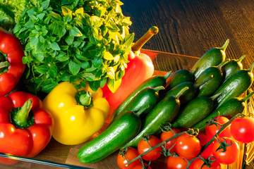 Fresh vegetables are on the table. Vegetables are illuminated with yellow light. Vegetarianism. A raw food diet. Vitamin diet. Preparation of a quick side dish. Vegetable still life.