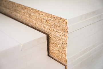 White textured chipboard pieces stacked in the workshop