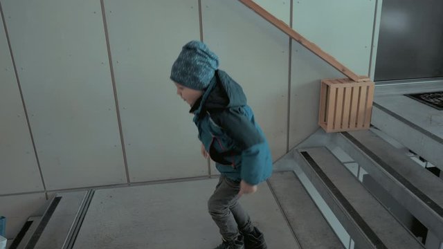 Kleiner s&uuml;sser Junge springt die Treppe hinunter
