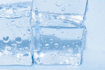 Ice cubes macro square with drops water clean on blue background