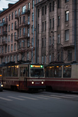 Plakat red tram rides along the street