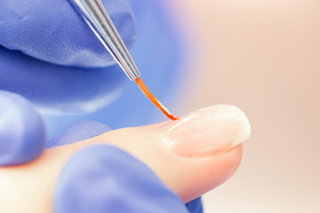 Macro photo of thin brush for manicure nails girl