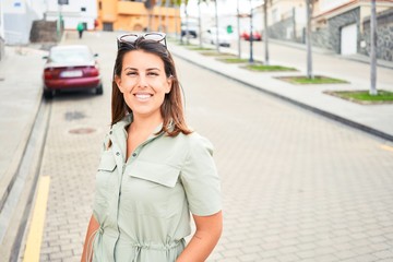 Fototapeta premium Young beautiful woman smiling happy walking on city streets on a sunny day of summer