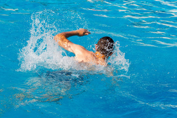 The guy swims in the pool. Rest at the resort_