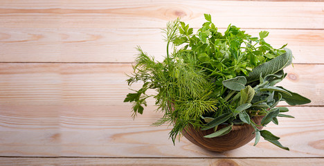 Bowl of fresh herbs leaf isolated on wooden background