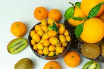Tropical fruits in bulk: orange, mandarin, kumquat, kiwi. Fresh fruits, food on a white background.