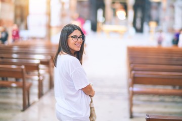 Fototapeta premium Young beautiful woman smiling happy and confident. Standing with smile on face at church