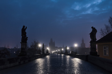 Female tourist walking alone on the Charles Bridge during the early morning in Prague, capital of...