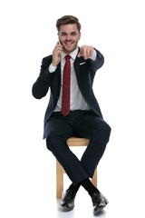 happy businessman talking on the phone and pointing finger