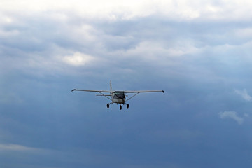 Yaslo, Poland - july 1 2018: A light sport turboprop aircraft flies across the sky among the rainy clouds. Landing in difficult weather conditions. Meteorology and weather forecast for aviation