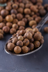 fresh spicy peppers allspice on a dark stone background