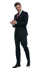 young businessman rubbing palms and looking to side
