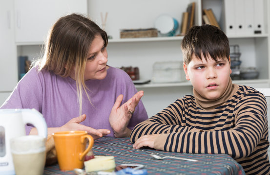 Sad Son And Unhappy Mom Having Quarrel During Breakfast Indoors