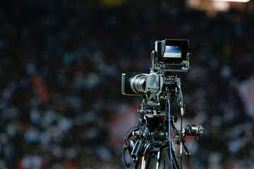 TV camera at the stadium, broadcasting during a football (soccer) match