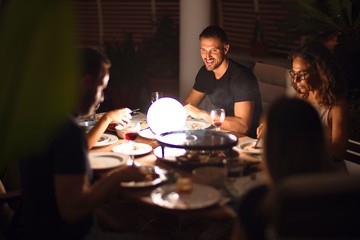 Beautiful family on dinner talking and smiling at terrace