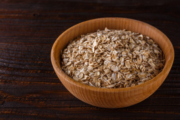 raw oatmeal on a wooden rustic background