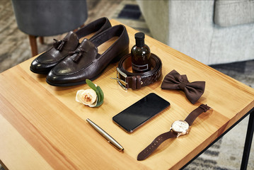 different accessories of a businessman for creating a style of a people lie on a wooden background