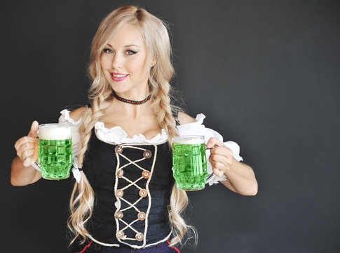 Beautiful woman in dress with a green irish beer. Happy St. Patrick's Day.