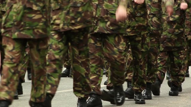 Army Soldiers parade through the streets in parade. They march in formation in camouflage. Marching. Close up of legs
