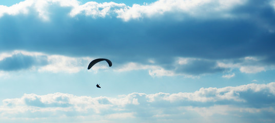 Paragliding extreme sport. Skydiving Parachute activity against blue dark sky
