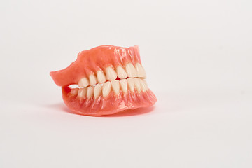 False prostheses. Dental hygienist checkup concept. Full removable plastic denture of the lower jaw.