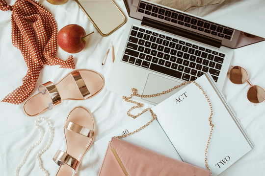 Women Fashion Pink Styled Home Work Space With Bijouterie On White Linen. Laptop, Slippers, Purse Bag, Sunglasses, Jewelry. Flat Lay, Top View Girl Boss Business Hero Header Concept.