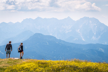 Hiking couple on mountain Hochobir, Austria, with Kamnik–Savinja Alps