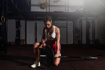 Young strong muscular fit girl with big muscles preparing for hard strength weightlifing or dead...