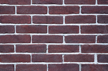 Brick wall background texture.Close-up of a facade panel of a brickwork of dark brown color.Selective focus.