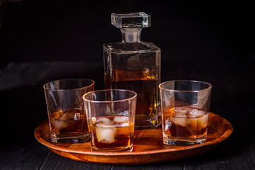 A tray with a carafe and three glasses of whiskey