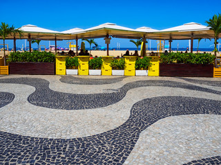 Copacabana beach with mosaic of sidewalk and kiosks in Rio de Janeiro, Brazil. Copacabana beach is...