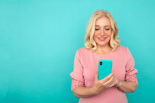 Happy Mature Woman With Mobile Isolated Over The Blue Background