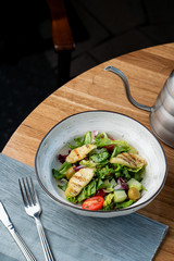Halloumi cheese salad with mixed greens and tomatoes top view