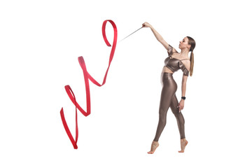 Fototapeta na wymiar Slender graceful girl gymnast in beige sportswear dancing with a red developing ribbon isolated on a white background.