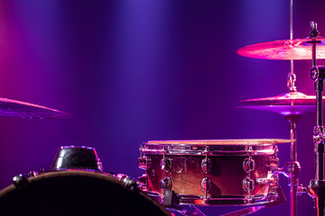 Drums and drum set. Beautiful blue and red background, with rays of light. Beautiful special effects of smoke and lighting. Musical instrument. Close-up photo.