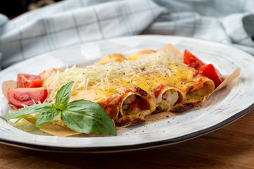 Cannelloni stuffed with turkey and vegetables, with melted cheddar and mozzarella cheese